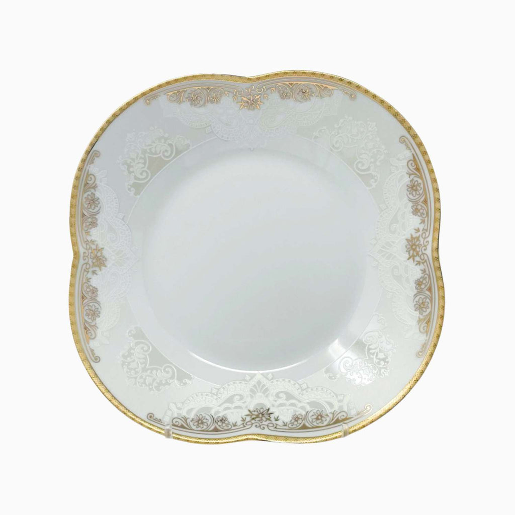 White ceramic plate with gold decorative rim on a white background