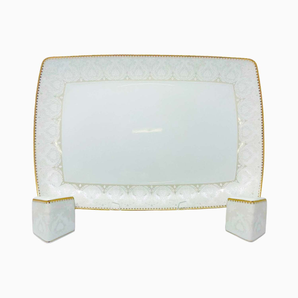Rectangular white plate with gold rim on a white background