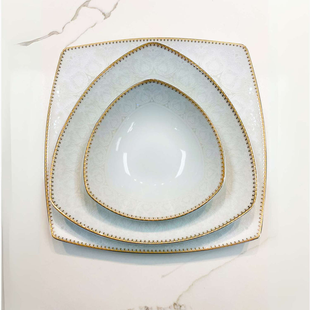 Set of square plates with gold rim on a marble surface