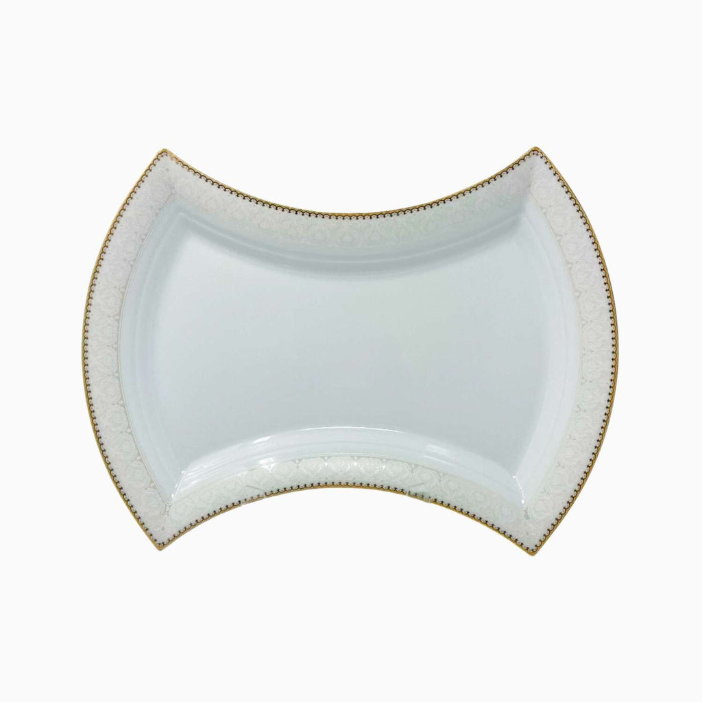 White ceramic dish with gold rim on a white background