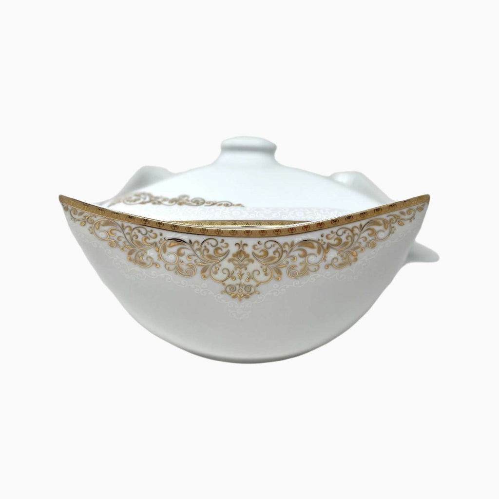 White ceramic tureen with gold decorative patterns on a white background