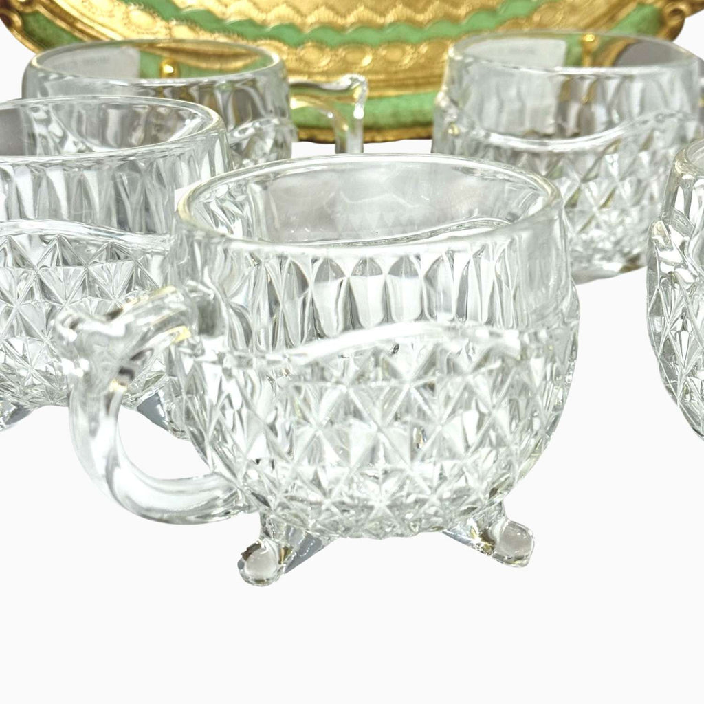 Set of clear crystal cups with a textured design on a white background