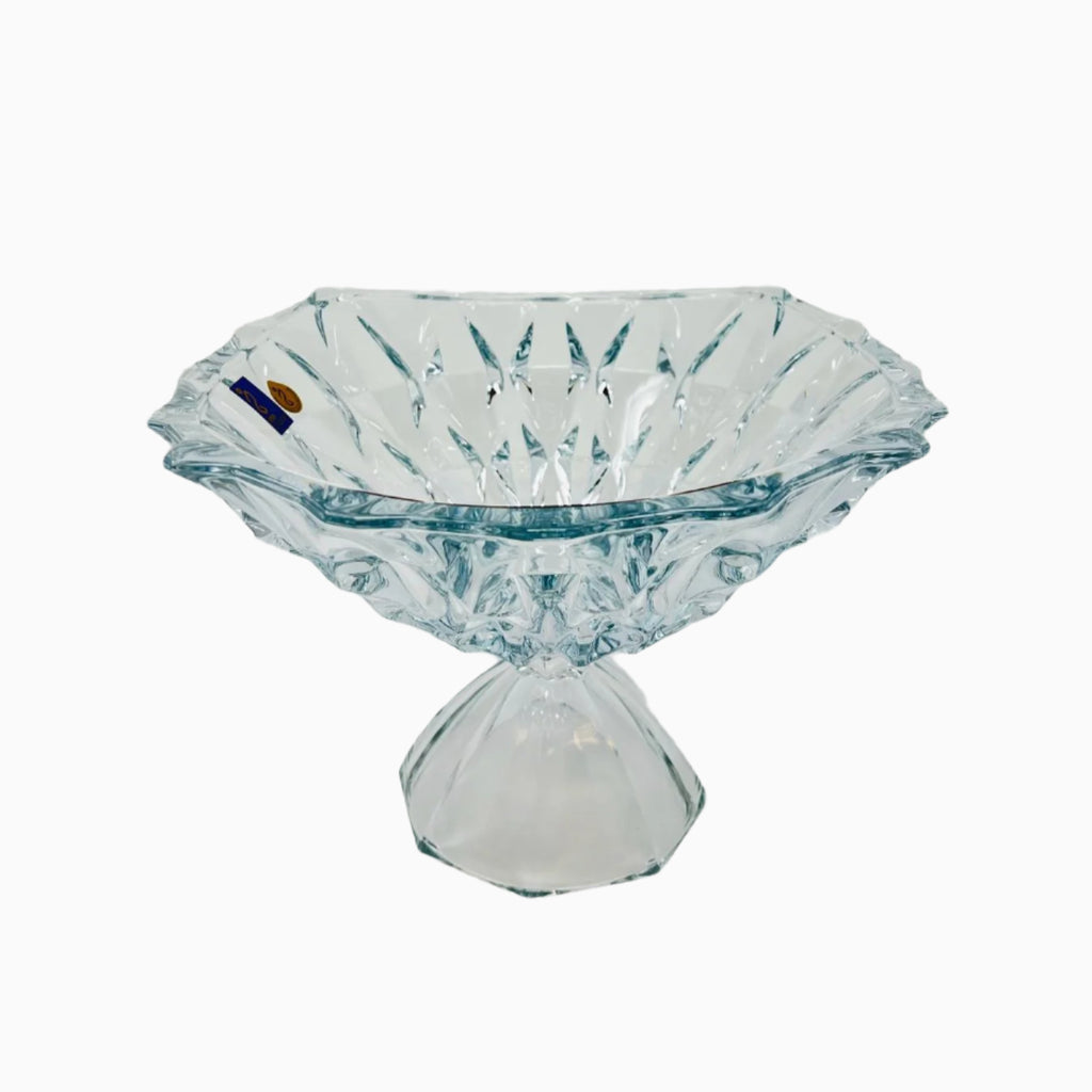 A clear glass decorative fruit bowl with a footed base.