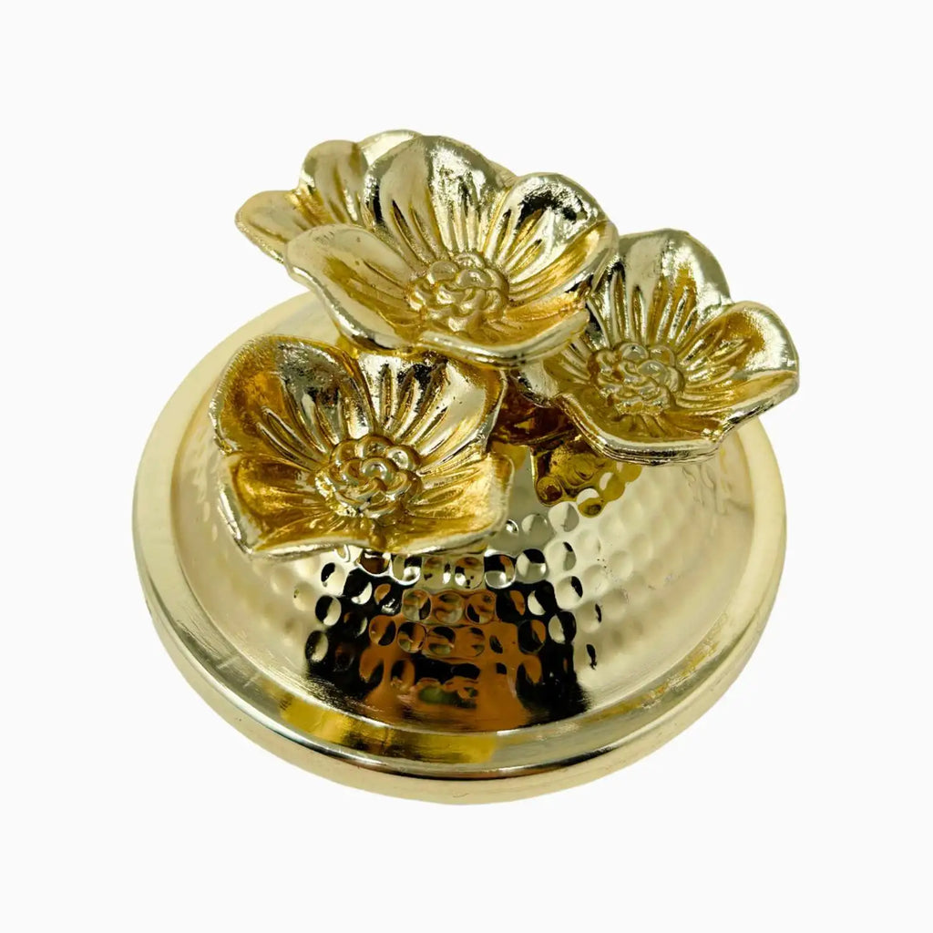 Gold decorative lid with floral designs on a white background