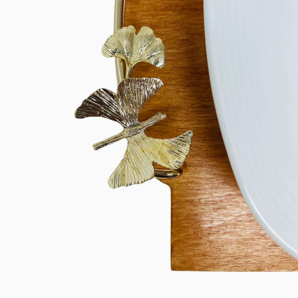 Gold leaf design on a wooden surface with a white plate in the background