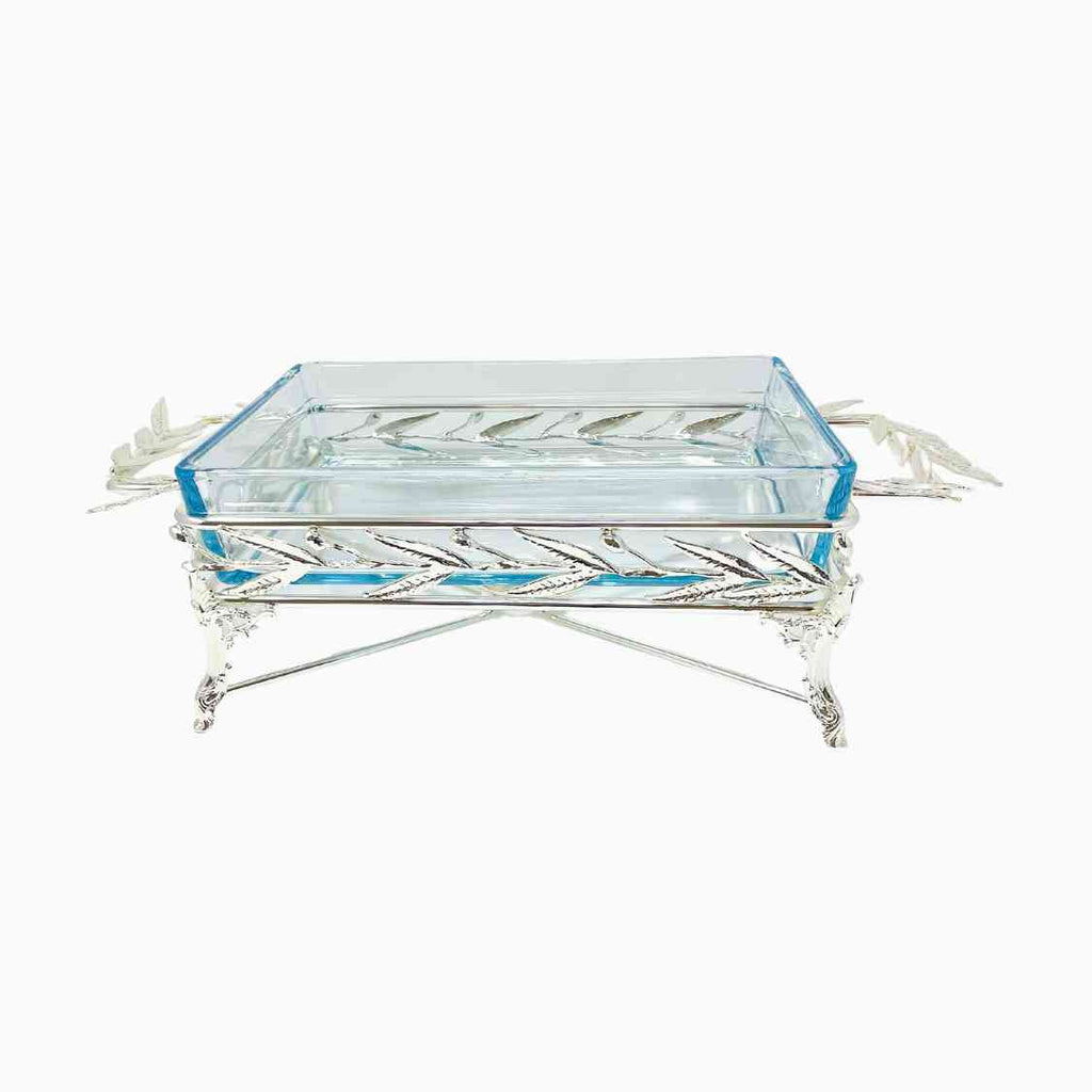 Elegant rectangular glass Pyrex serving dish set in an intricately crafted silver-tone metal stand featuring detailed leaf motifs and sculpted legs. Noble Home Gifts