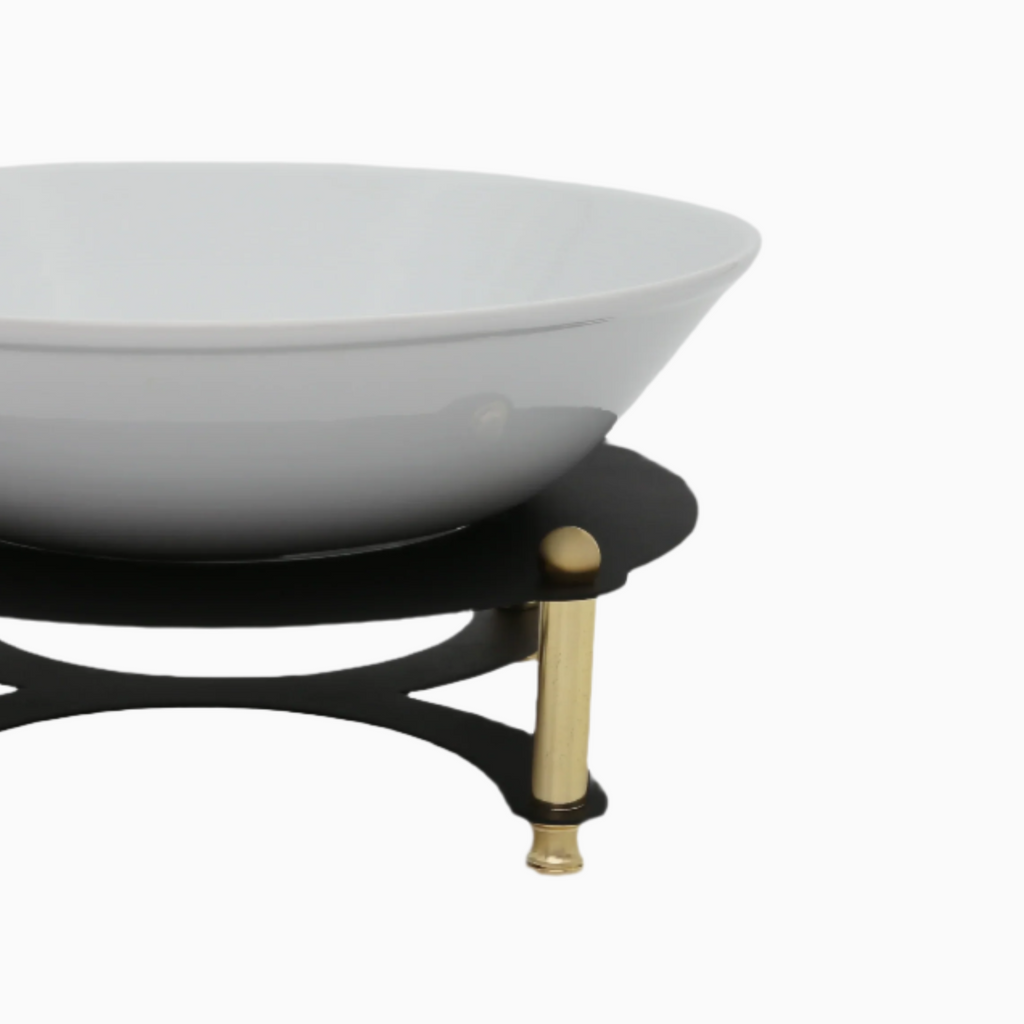 White bowl on a black stand with gold accents