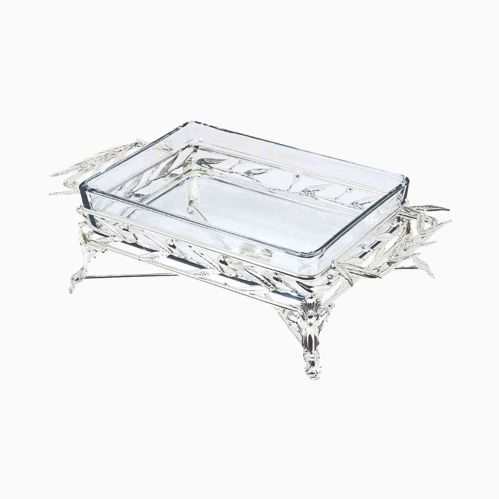 Elegant rectangular glass Pyrex serving dish set in an intricately crafted silver-tone metal stand featuring detailed leaf motifs and sculpted legs. Noble Home Gifts