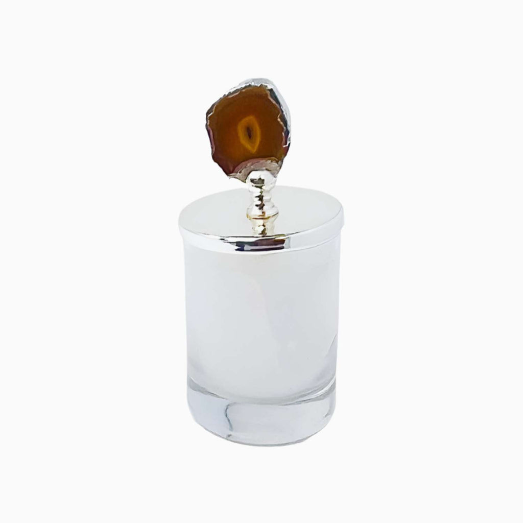 Clear glass candle holder with a brown decorative stone top on a white background